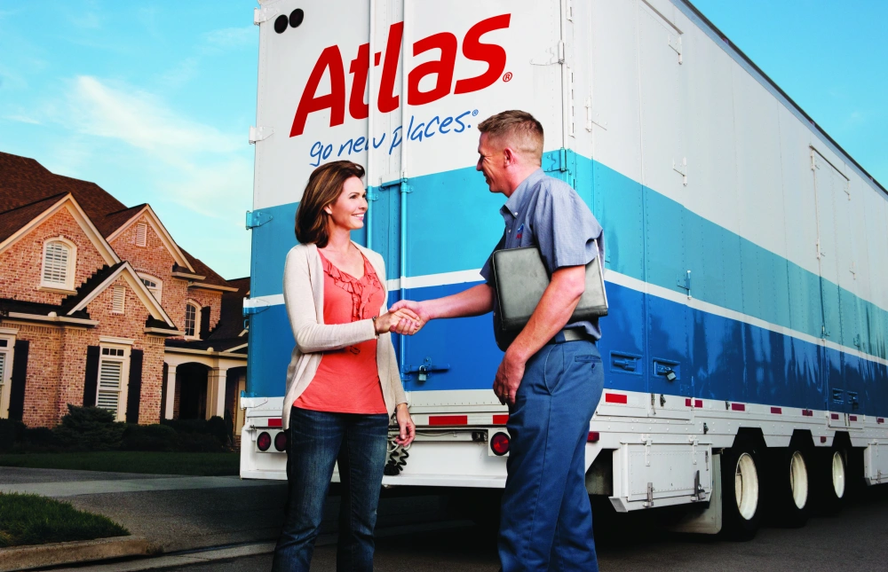 Man and woman shaking hands in front of Atlas moving van